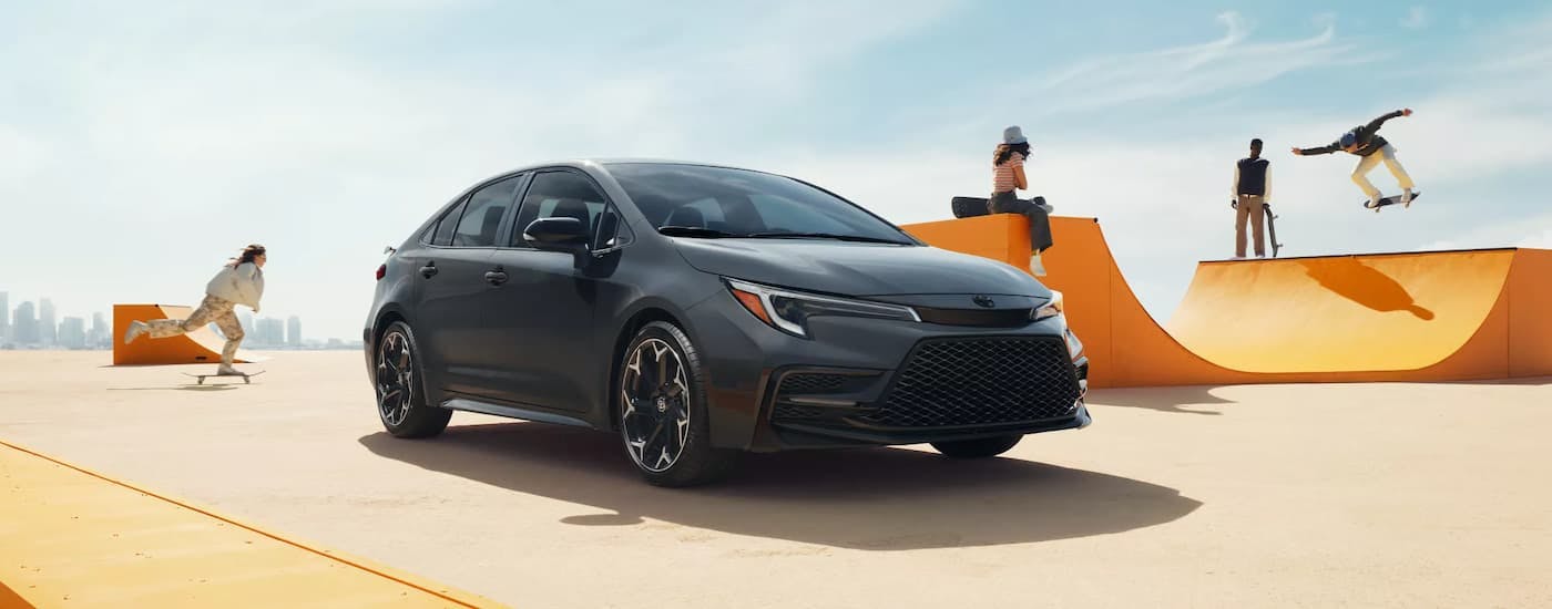 Black 2026 Toyota Corolla Hybrid parked near a skate park.