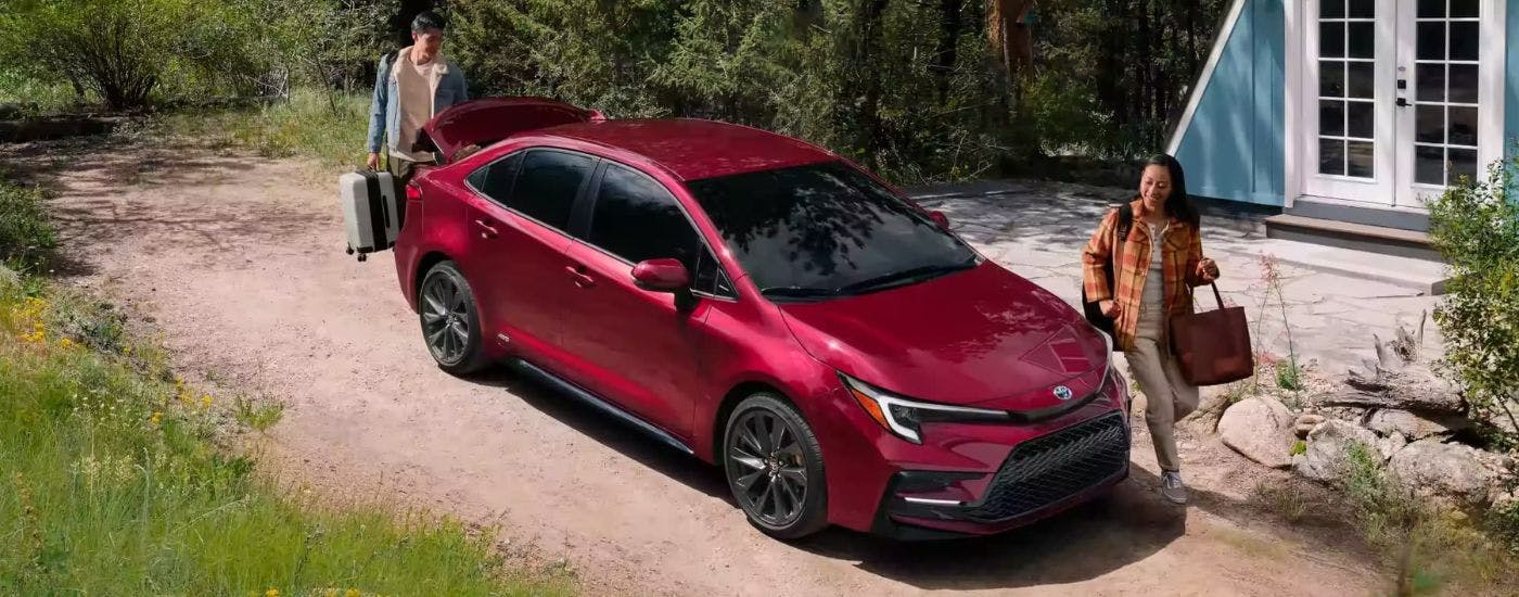 Two people packing a red 2026 Toyota Corolla