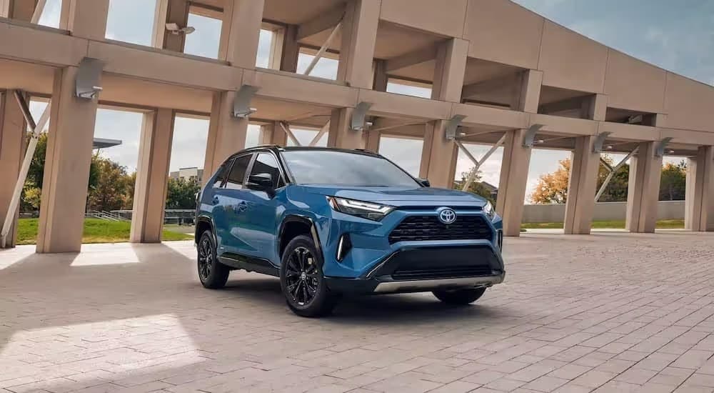 A blue 2023 Toyota RAV4 parked near a Toyota dealer.