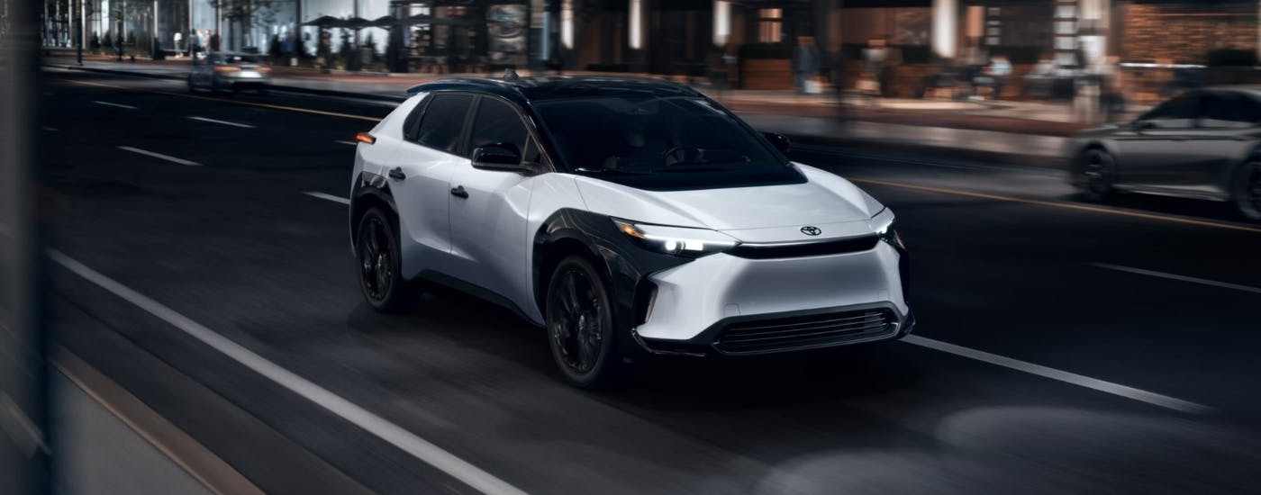 White 2025 Toyota bZ4X Nightshade driving to a Toyota dealer