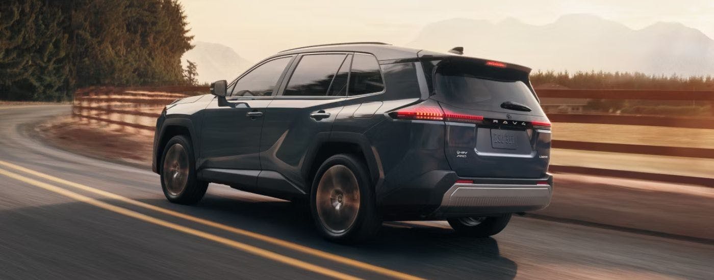 Blue 2026 Toyota RAV4 driving on an open road