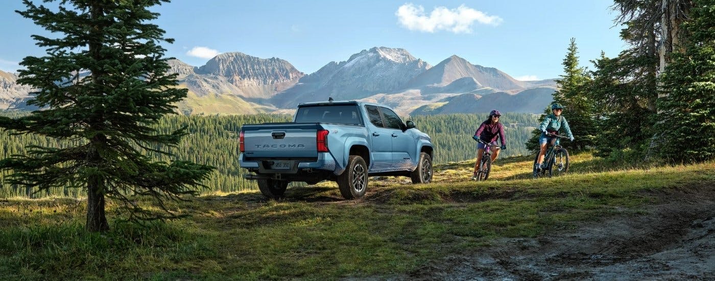 People biking near a blue  2026 Toyota Tacoma TRD Sport