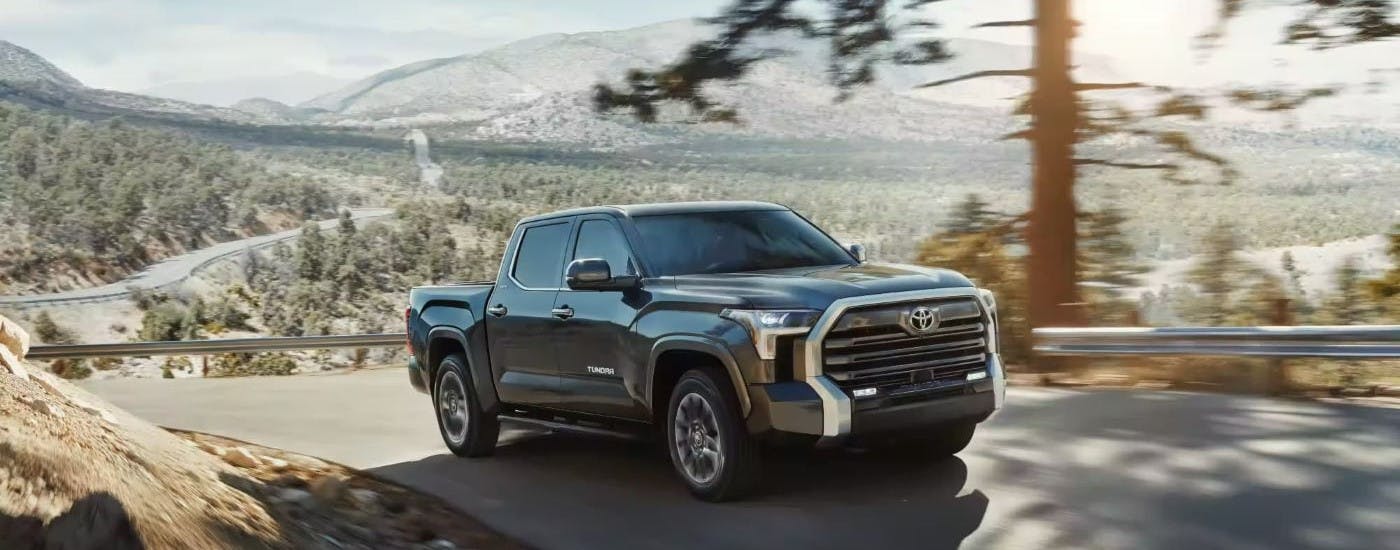 Gray 2023 Toyota Tundra driving on a hill