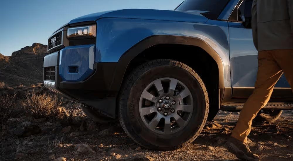 A close up of the front of a blue 2024 Toyota Land Cruiser after leaving a Toyota dealer near Powder Springs.