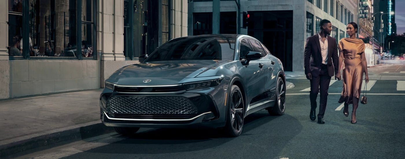Couple walking near a blue 2026 Toyota Crown