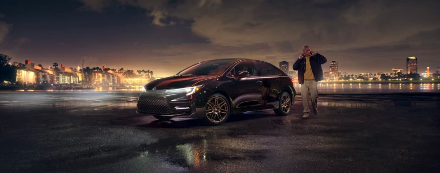 Black 2024 Toyota Corolla parked near a city at night