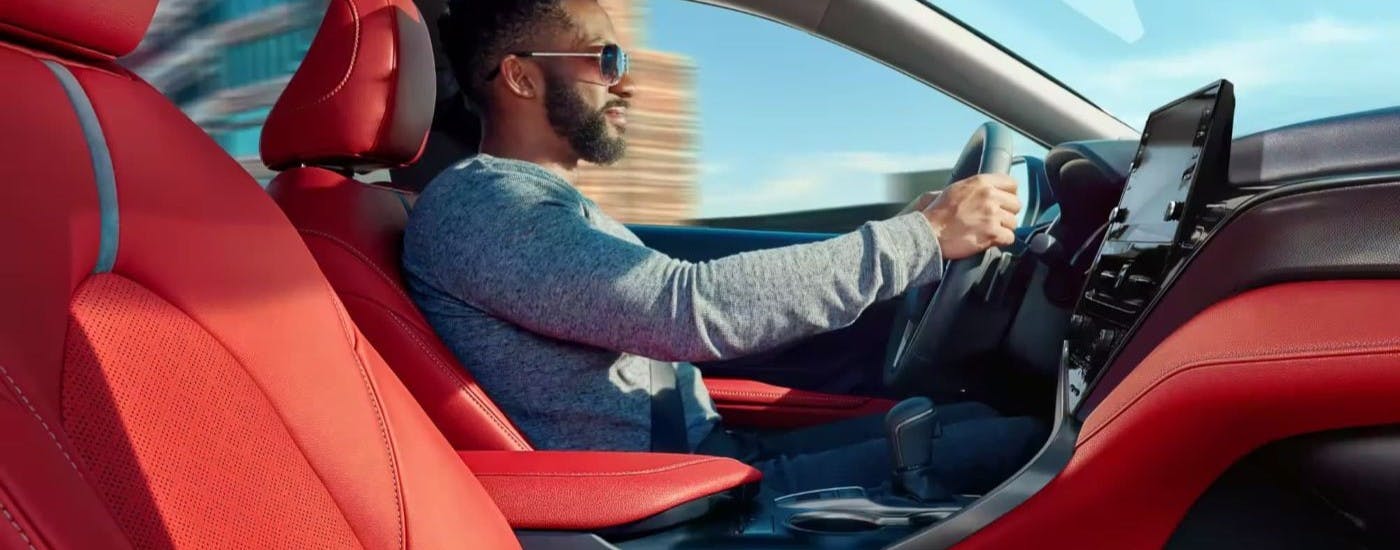 A person driving a 2023 Toyota Camry toward a Toyota dealer in Marietta