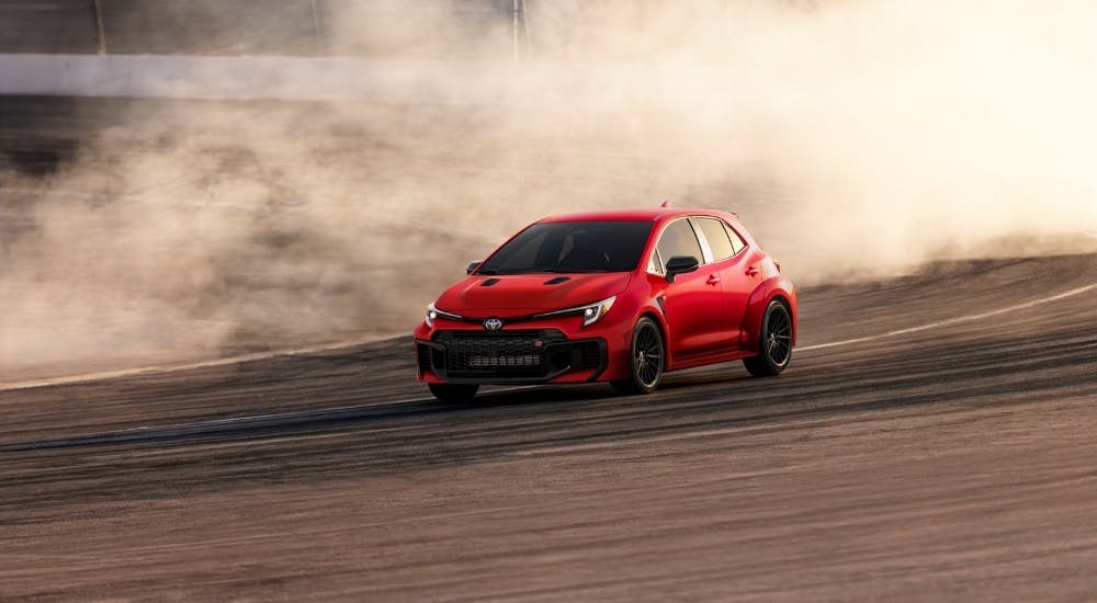 Red 2025 Toyota GR Corolla drifting on a racetrack