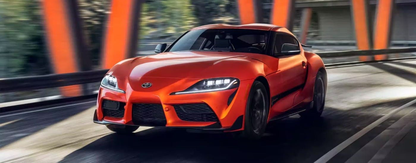 Orange 2024 Toyota GR Supra for sale rounding a corner
