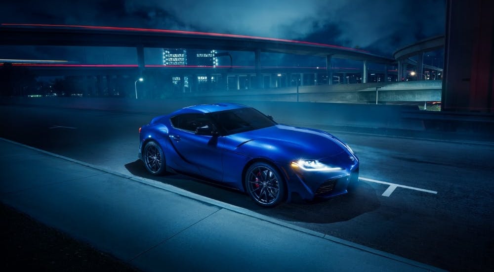 Blue 2025 Toyota GR Supra 3.0 Premium parked outside a city on a foggy night