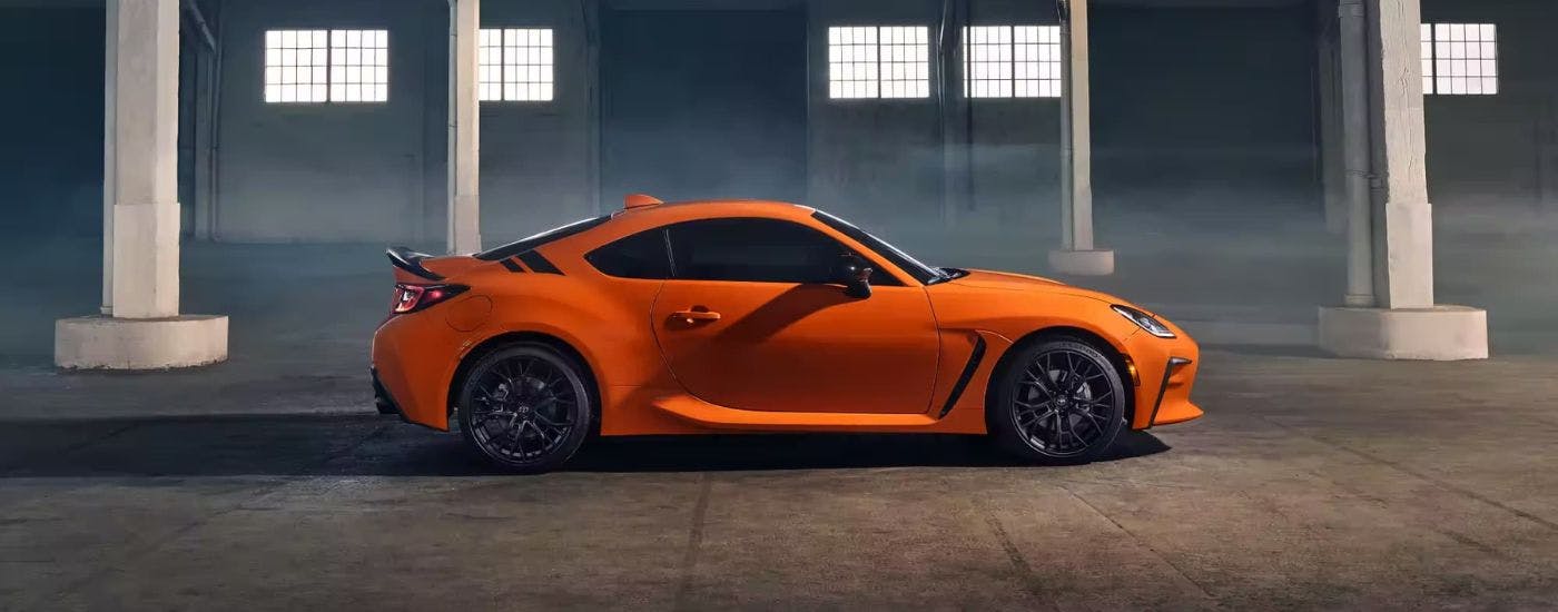 Side angle of a 2023 Toyota GR86 for sale parked in a building