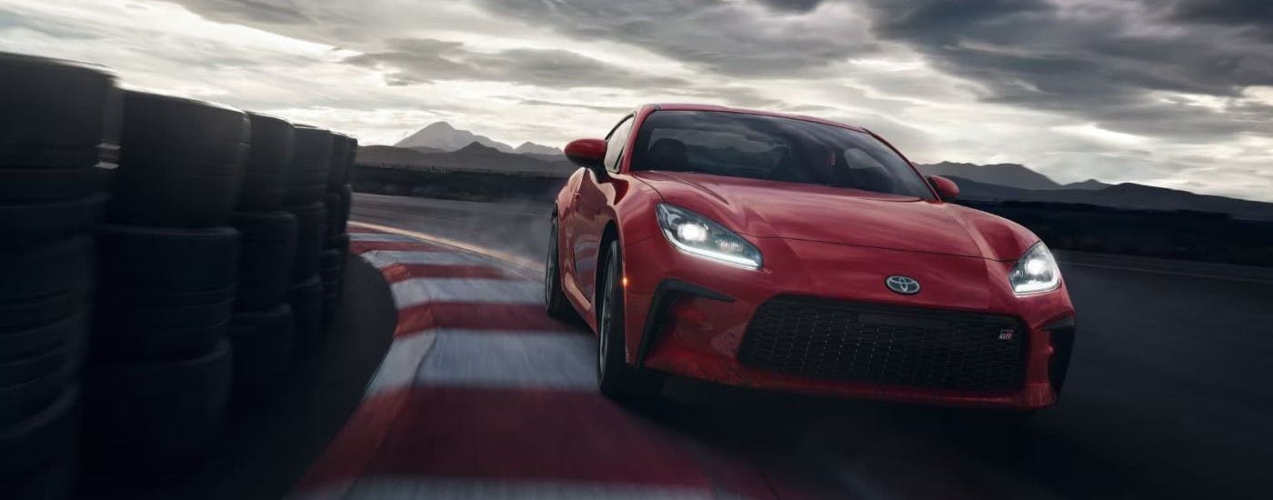 Red 2023 Toyota GR86 driving around a track