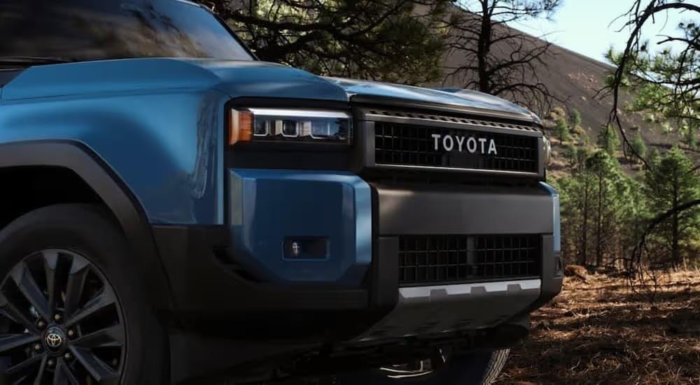 A close-up of the grille on a blue 2024 Toyota Land Cruiser is shown.