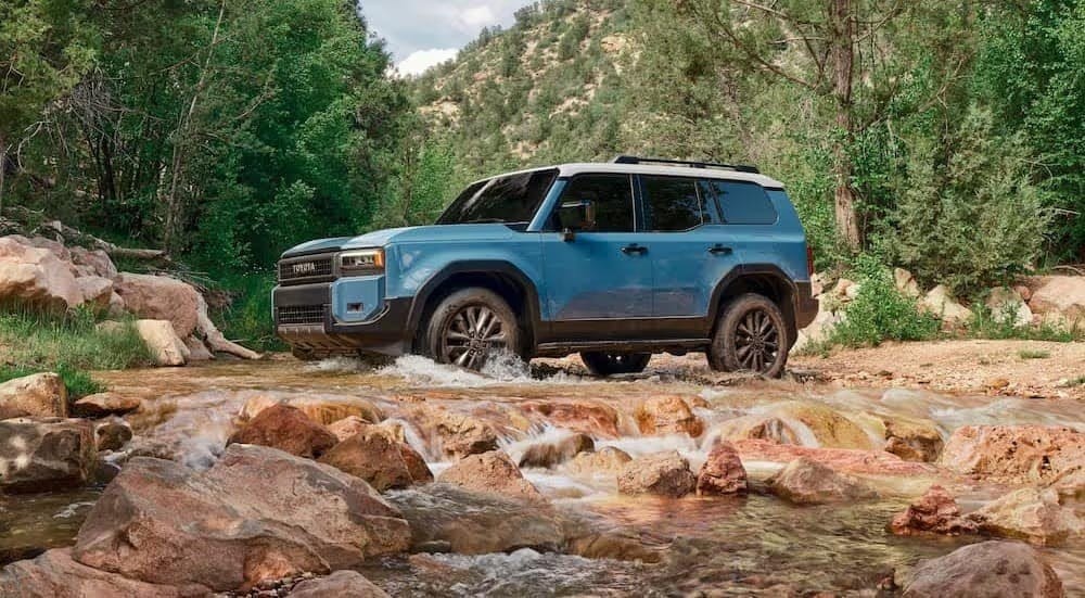 A blue 2024 Toyota Land Cruiser for sale is shown driving on water.