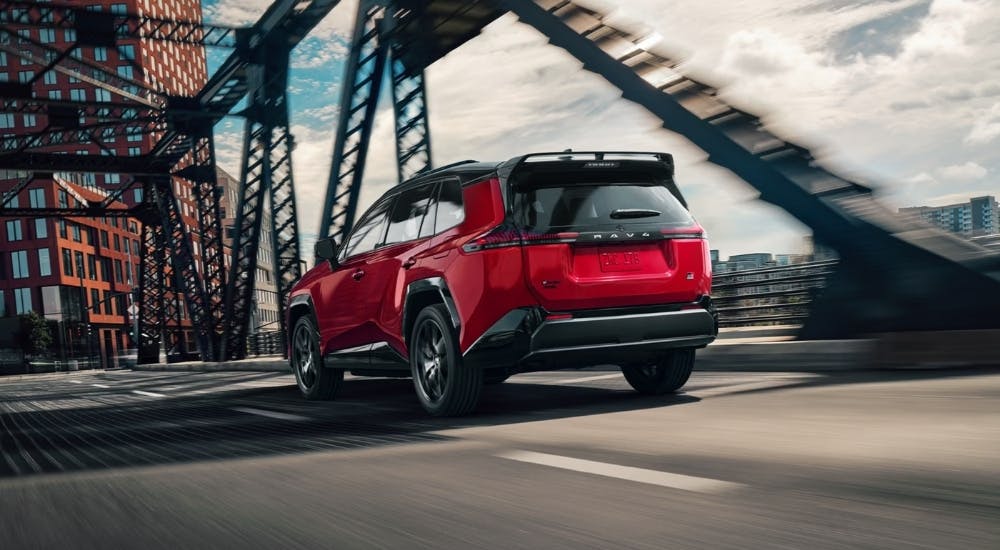 A red 2026 Toyota RAV4 GR Sport driving on a bridge.