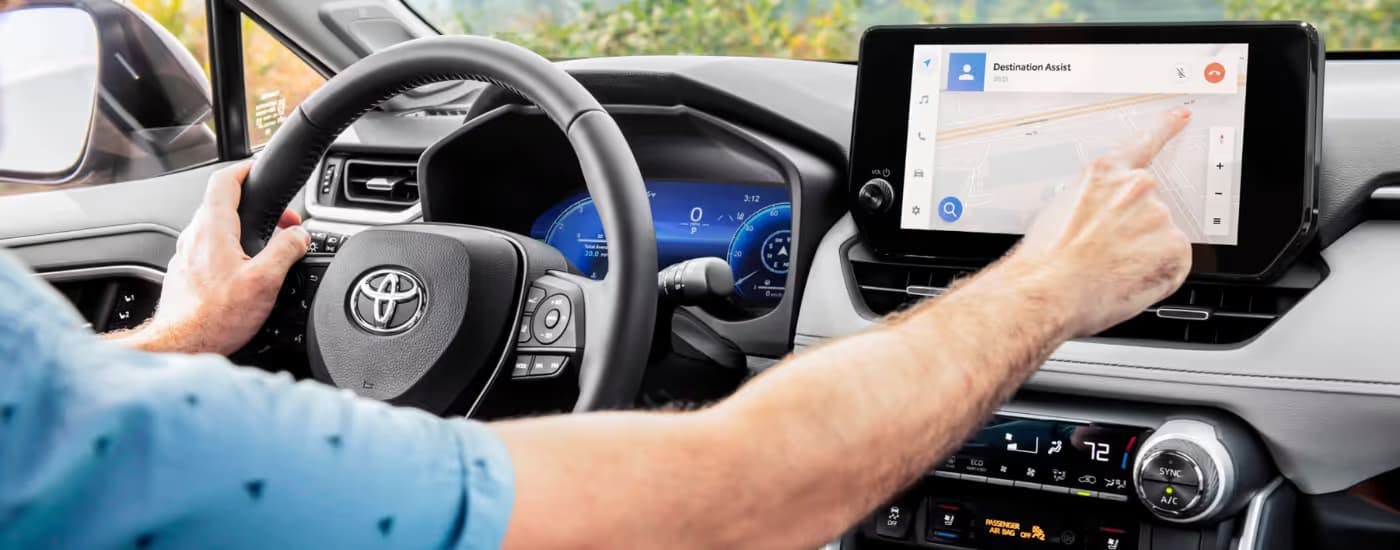 Person using the infotainment screen inside of a 2025 Toyota RAV4.