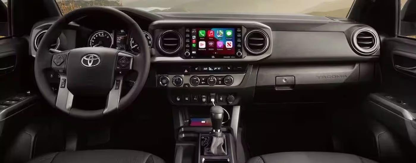 The black interior of a 2022 Toyota Tacoma Trail is shown from above the center console.