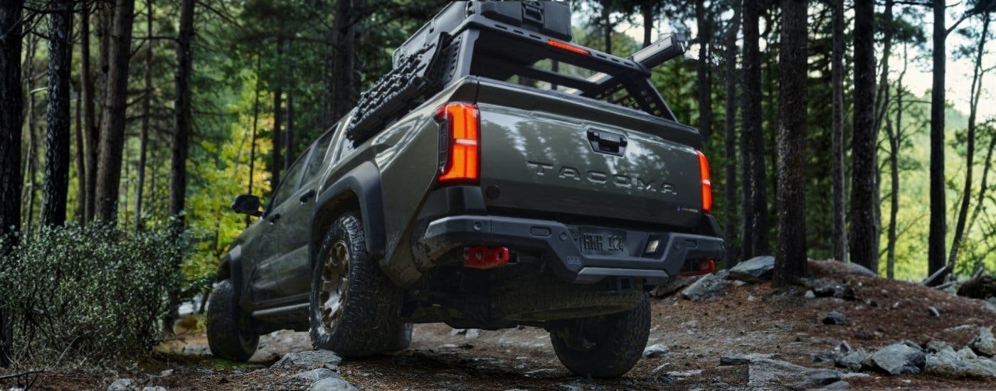 A green 2024 Toyota Tacoma off-roading on a trail