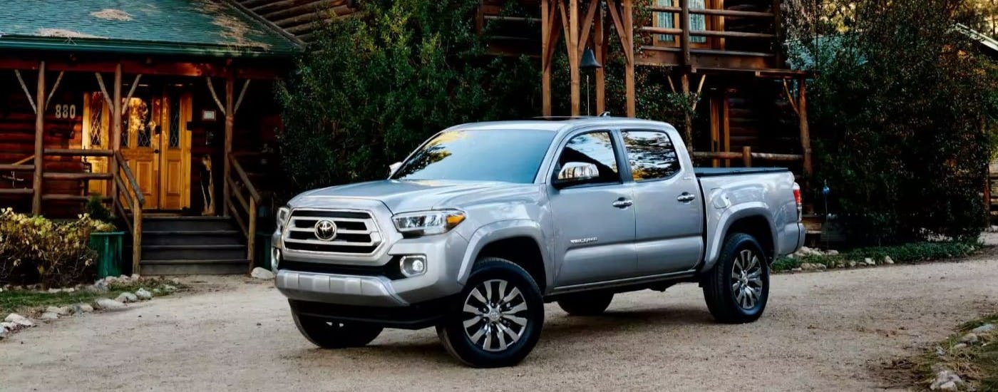 Silver 2023 Toyota Tacoma for sale near Smyrna parked near a log cabin