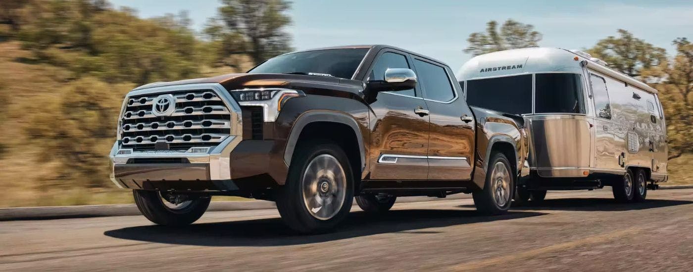 Brown 2024 Toyota Tundra 1794 Edition towing a trailer to Toyota Tundra dealer