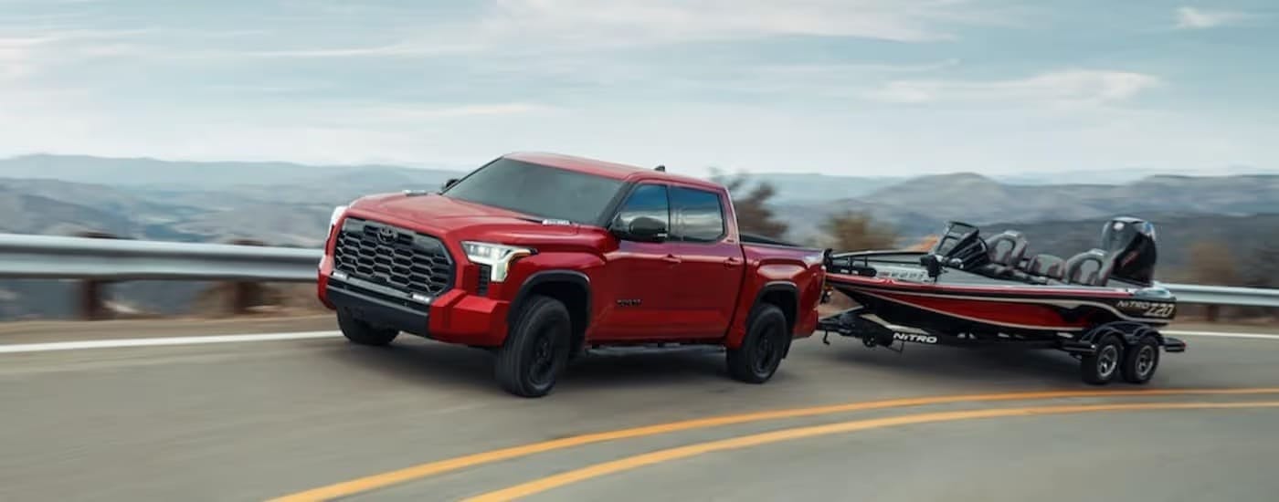 Red 2024 Toyota Tundra towing a boat.