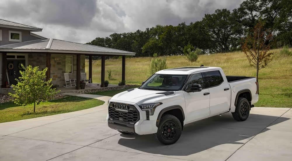 A popular Toyota Tundra for sale, a white 2023 Toyota Tundra TRD Pro, is shown parked near a house.