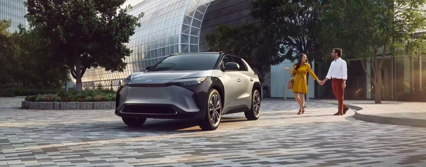 Silver 2023 Toyota bZ4X Limited with a couple walking up