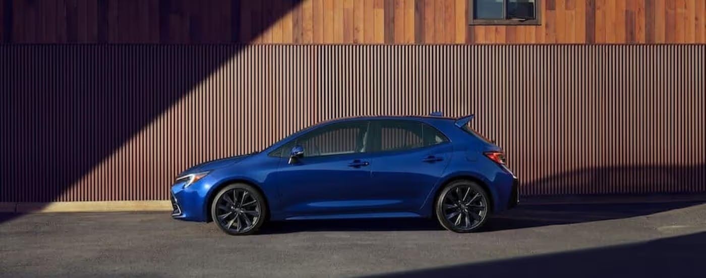 A blue 2024 Toyota Corolla Hatchback is shown parked near a wall.