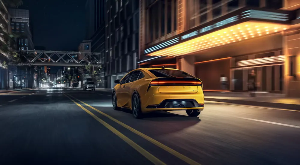 Yellow 2026 Toyota Prius driving down a city street.