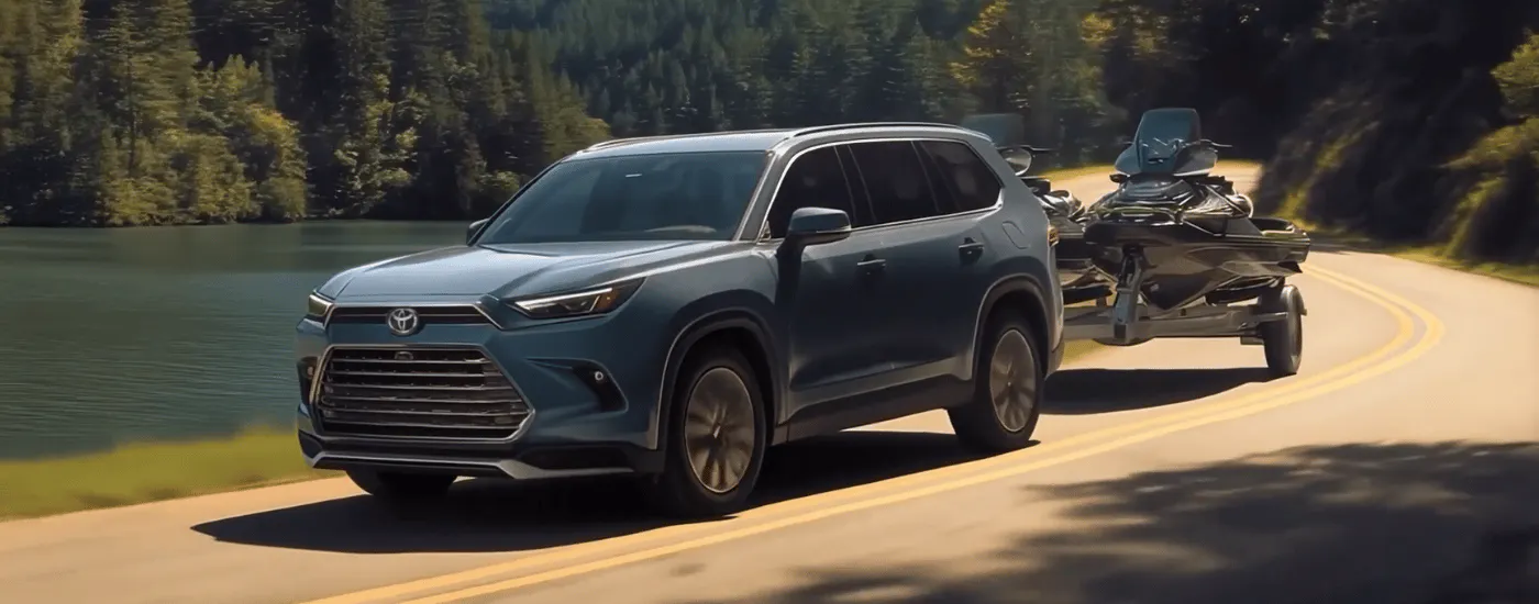 Blue 2026 Toyota Grand Highlander towing a pair of jetskis