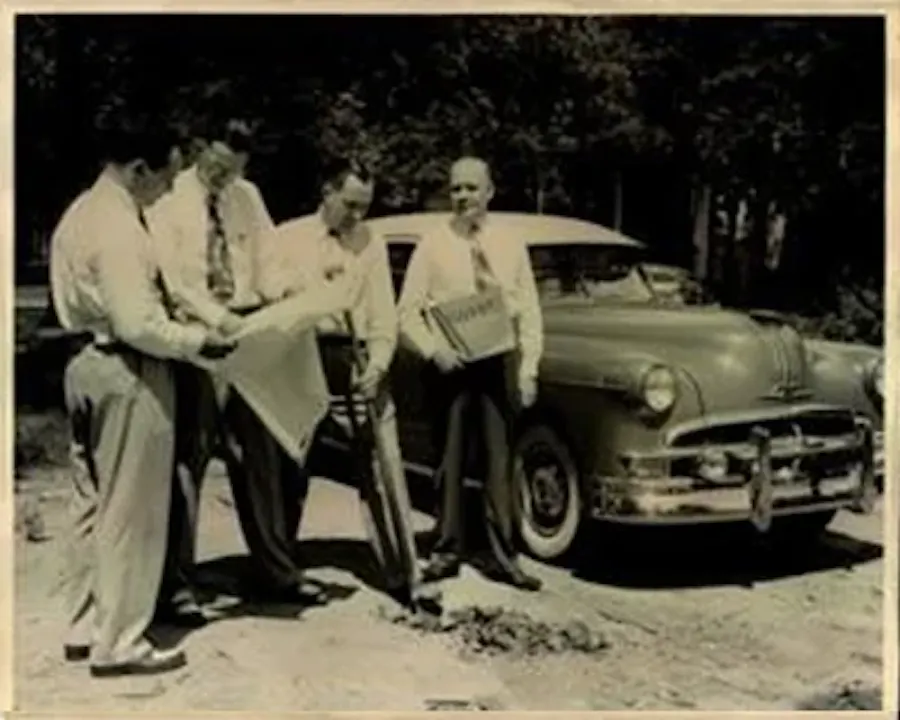People gathered by a car