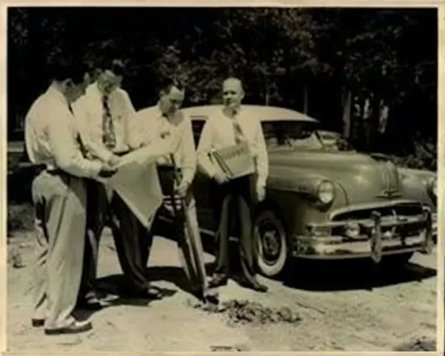 People gathered by a car