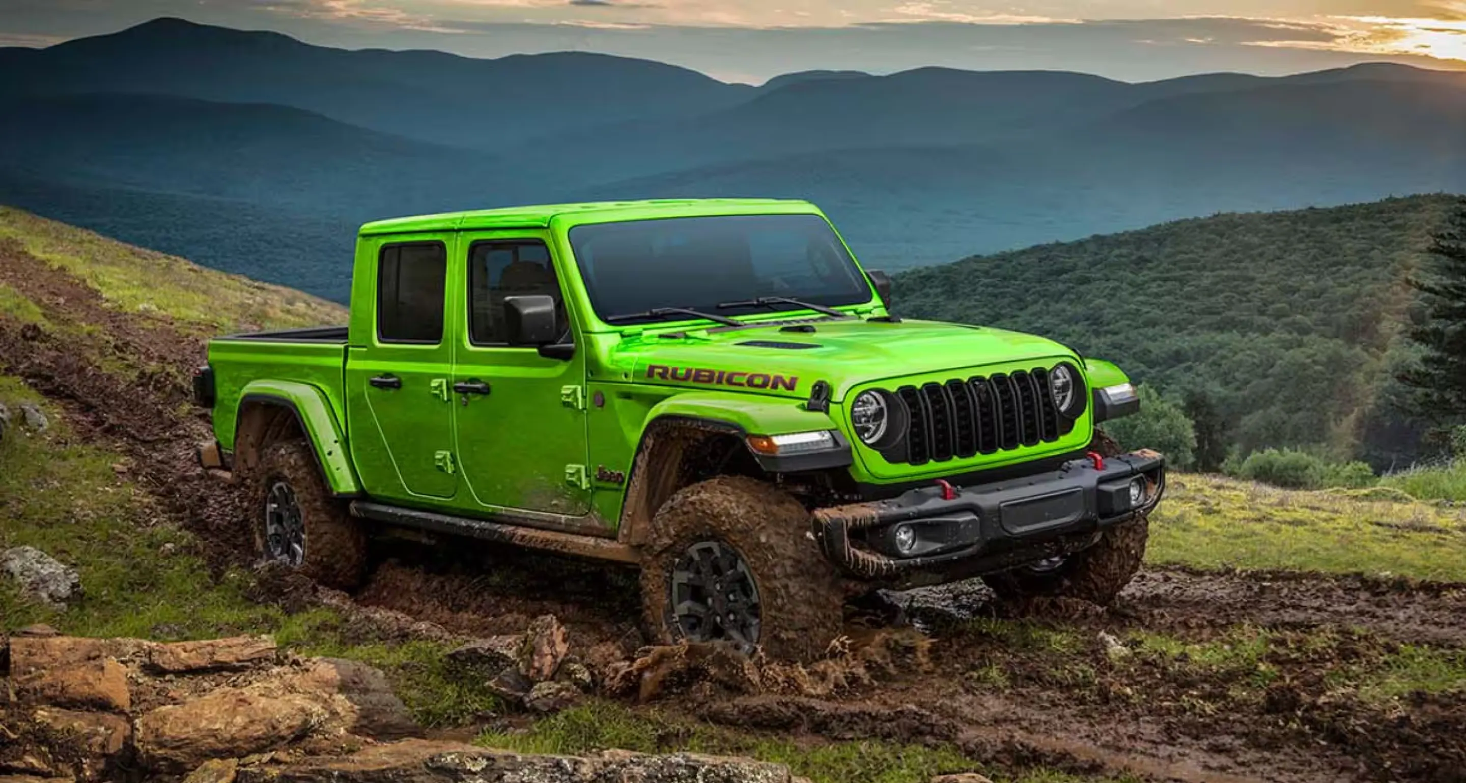 Bright green Jeep pickup driving through mud on a rugged hillside with mountains in the distance.