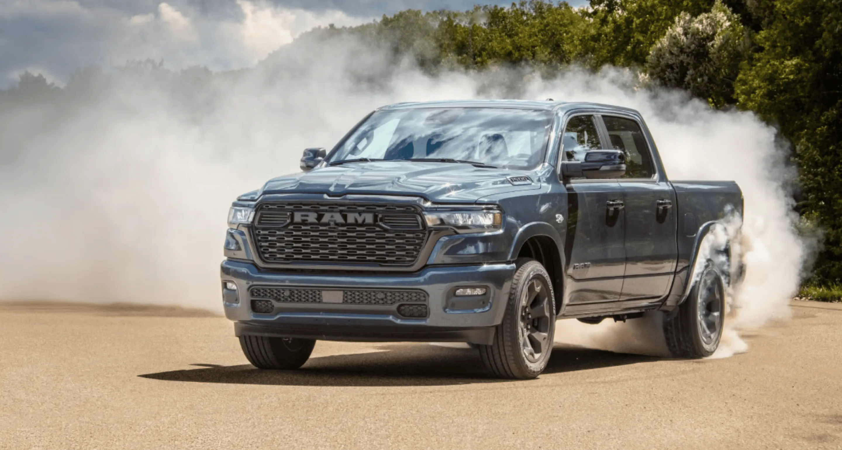 Blue Ram pickup truck turning on pavement with tire smoke billowing behind it.