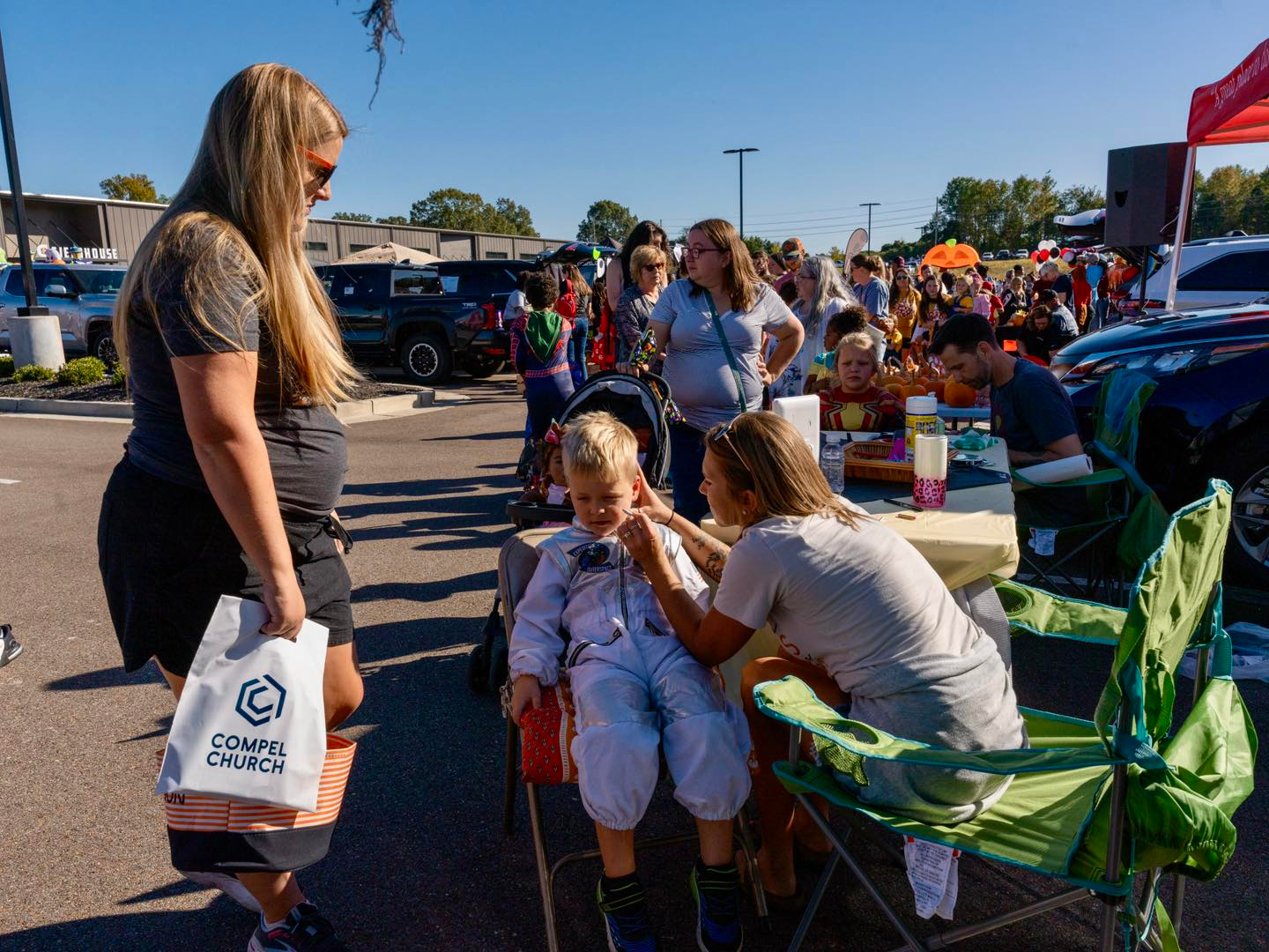a mom watching as her son get his face pained