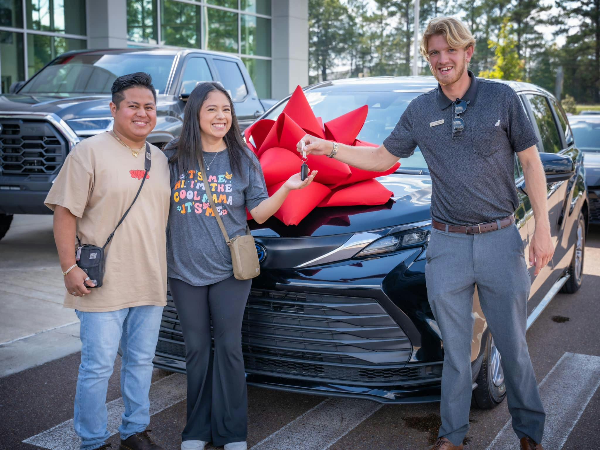 a happy couple getting handed keys to a new Sienna