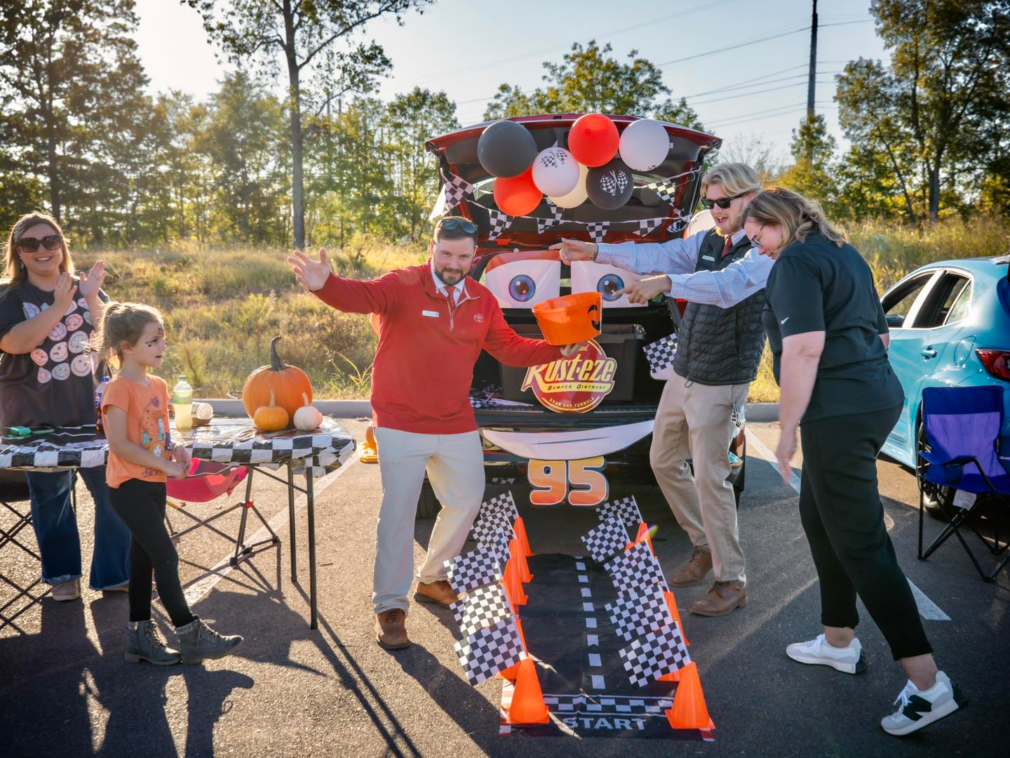 Toyota Sales men celebrating with a trick or treater