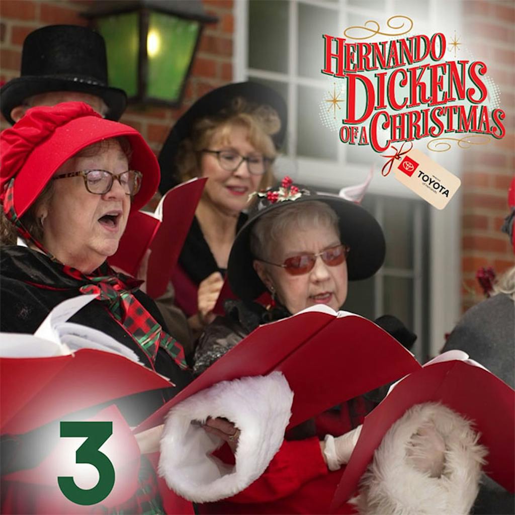 caroling at the event Carolers singing and reading lyrics from books