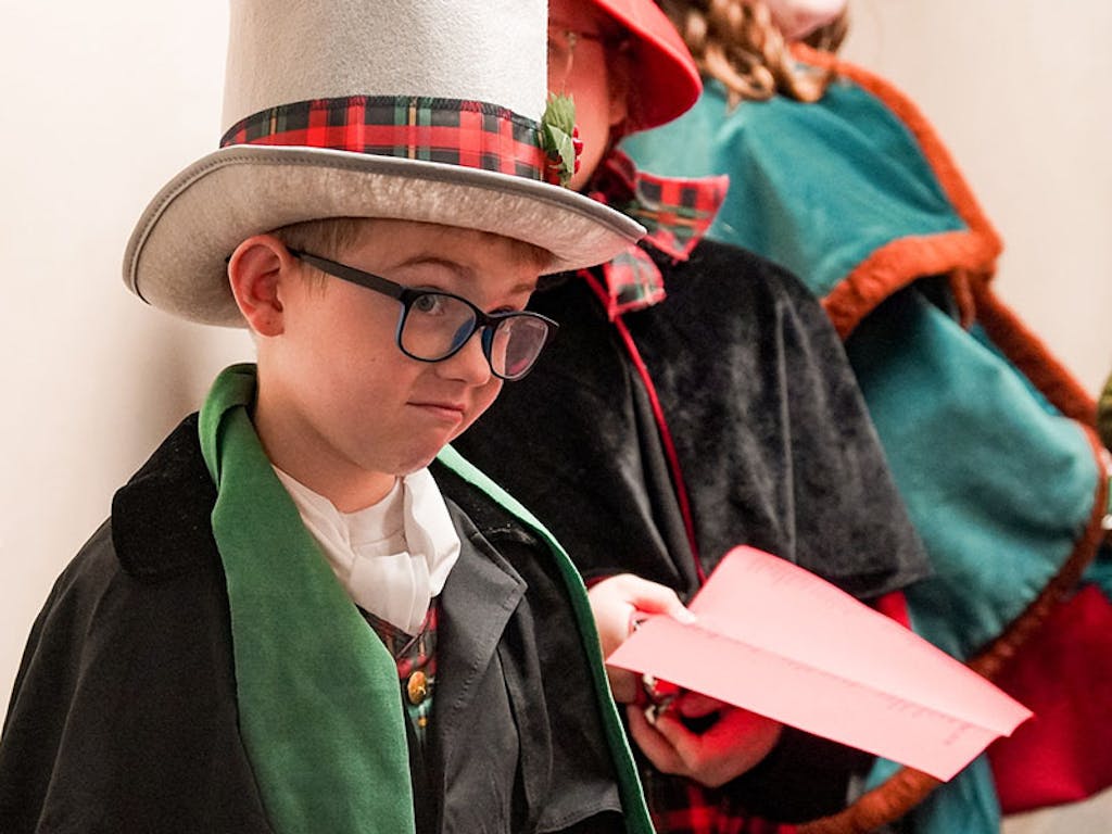 tophat-kid-singing A child wearing a top hat at the event taking a break from caroling