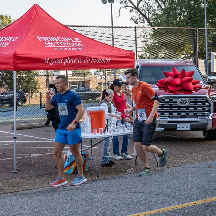 water-tower-10k-runnier-get-a-drink Runners in the 10K event stop by a tent and grab some water to hydrate
