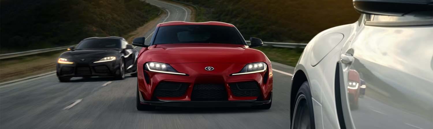 Three 2025 Toyota GR Supras driving on highway.