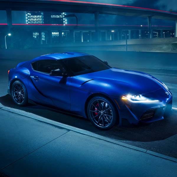 Blue 2025 Toyota GR Supra parked on foggy road at night.