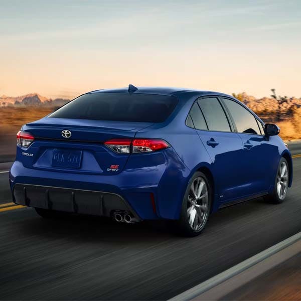 Rear of blue 2025 Toyota Corolla driving on desert highway.