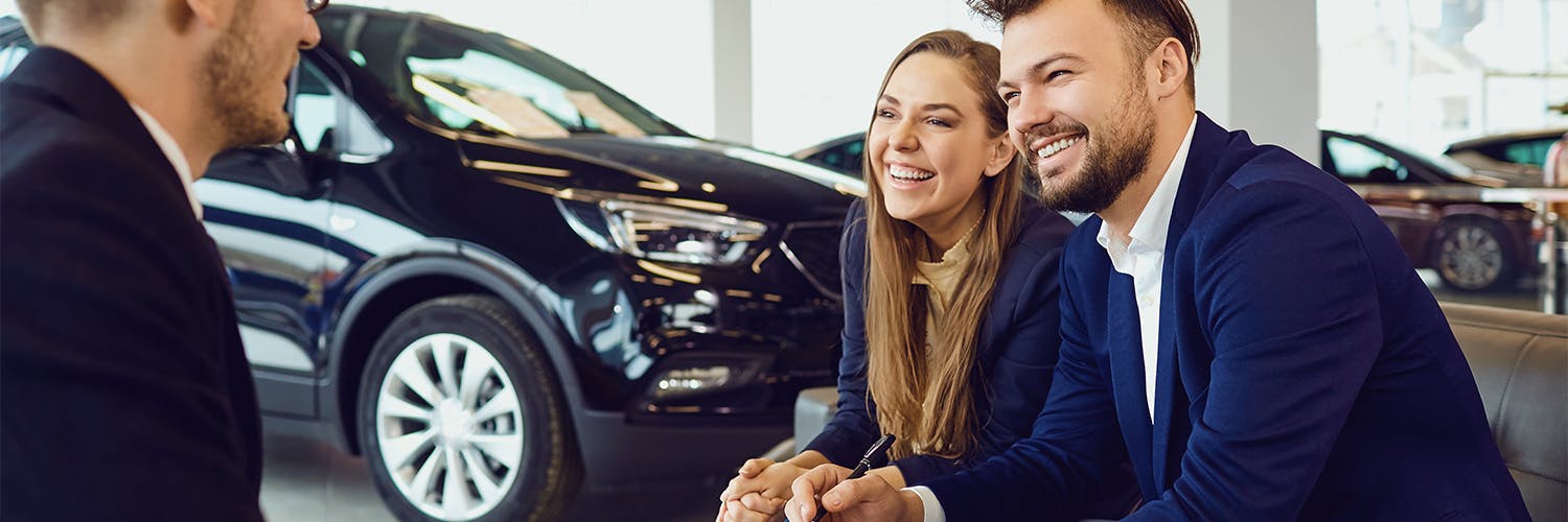 customers speaking with salesperson at a car dealership