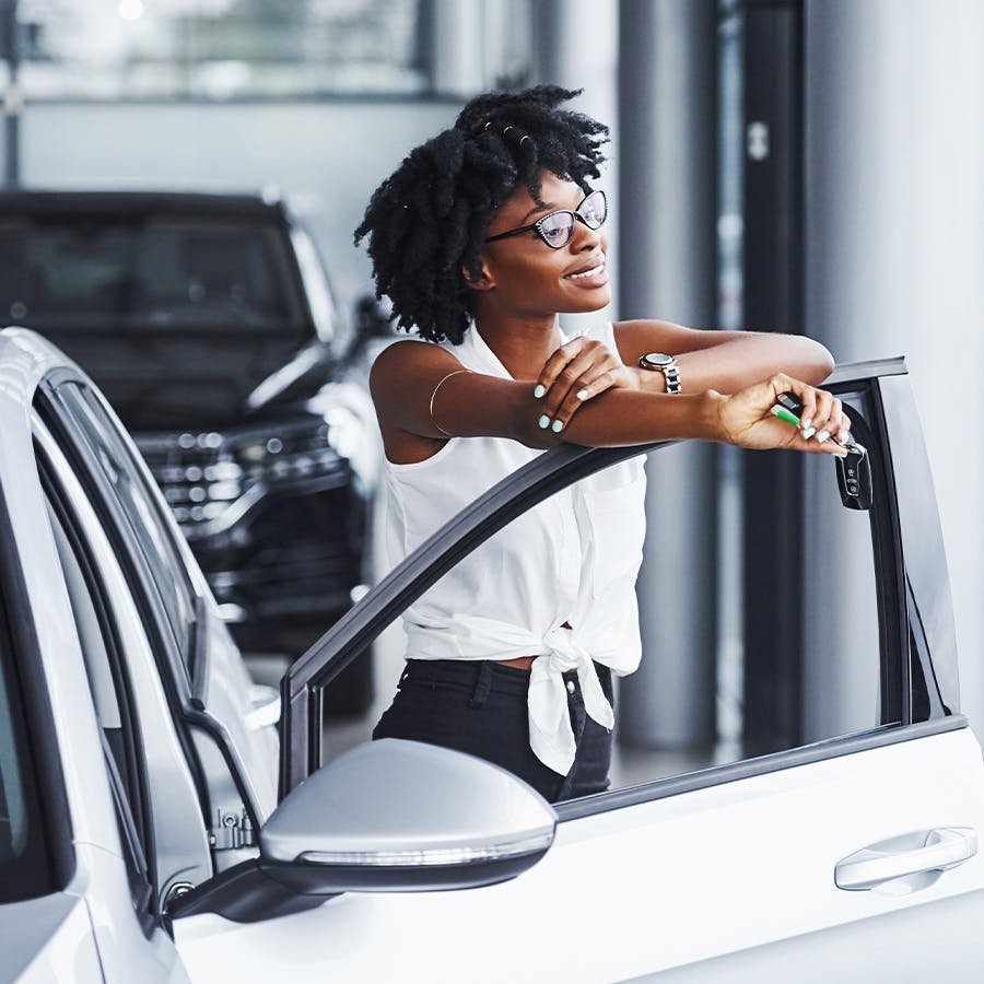 person smiling and resting on drivers side door