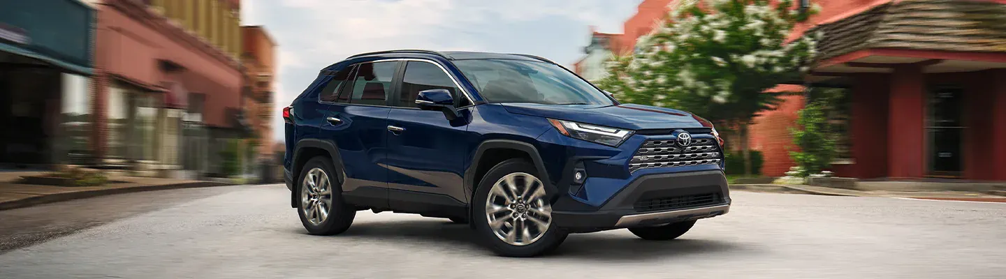 A dark blue RAV4 turns the street corner.