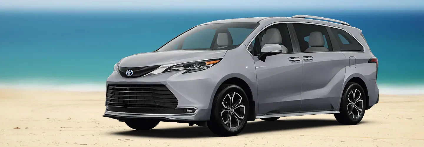 Grey Toyota Sienna van parks on beach.