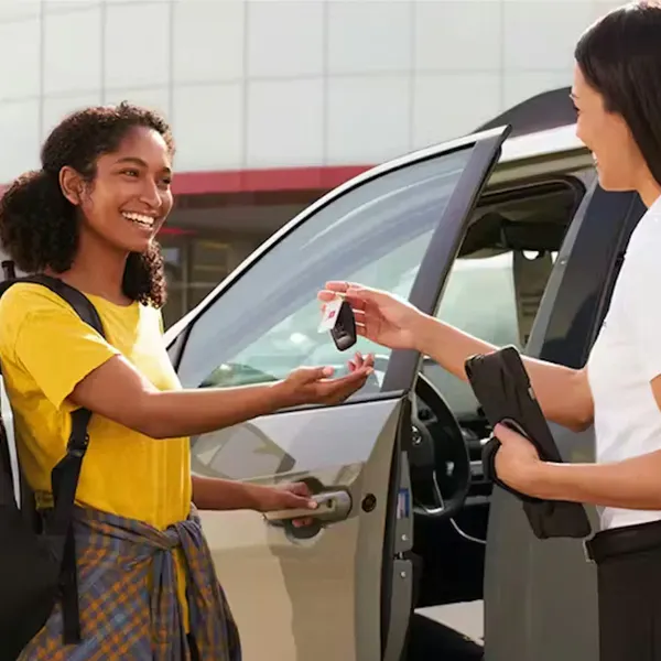 Sales associate exchanges keys with new buyer