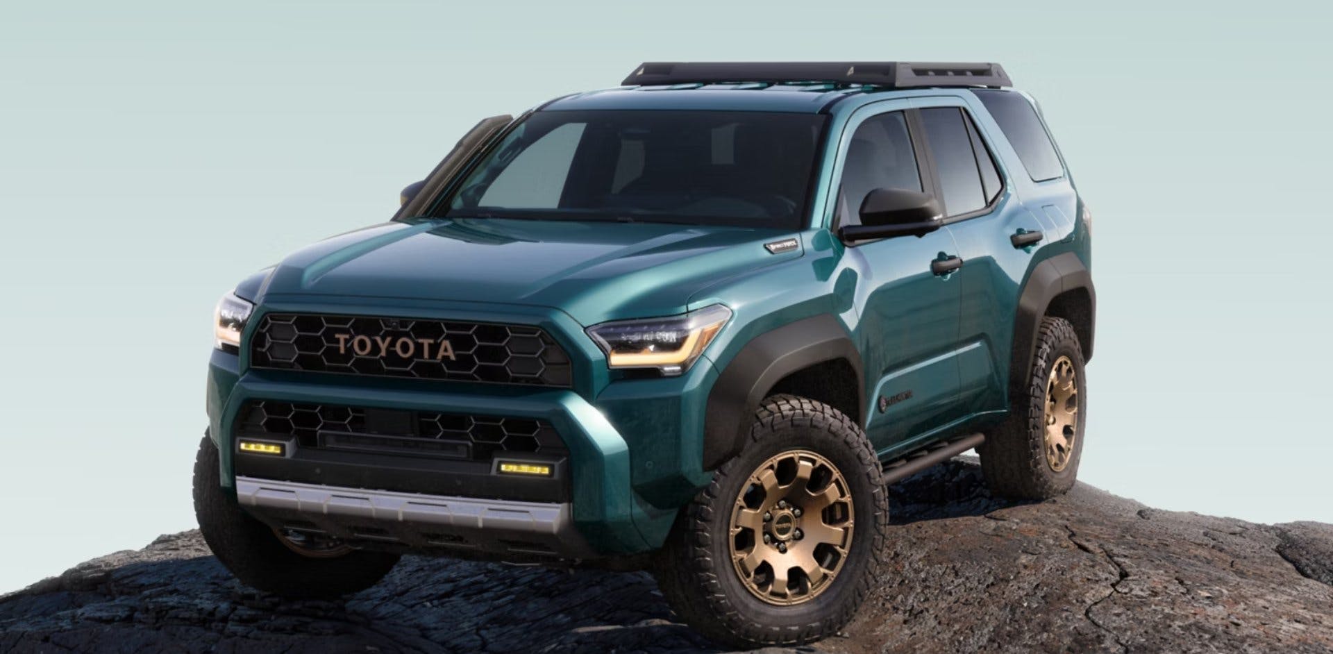 Green Toyota 4Runner parked on a large rock