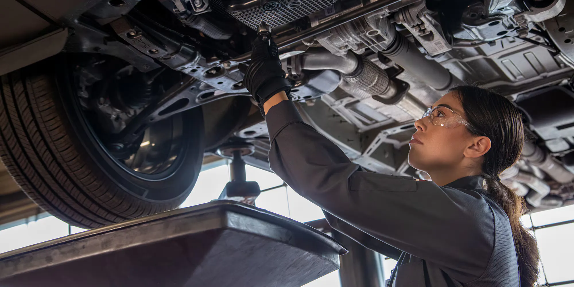 a view of a certified chevy service member working on the under side of a chevy vehicle